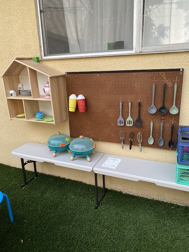 Children playing with an outdoor pretend kitchen