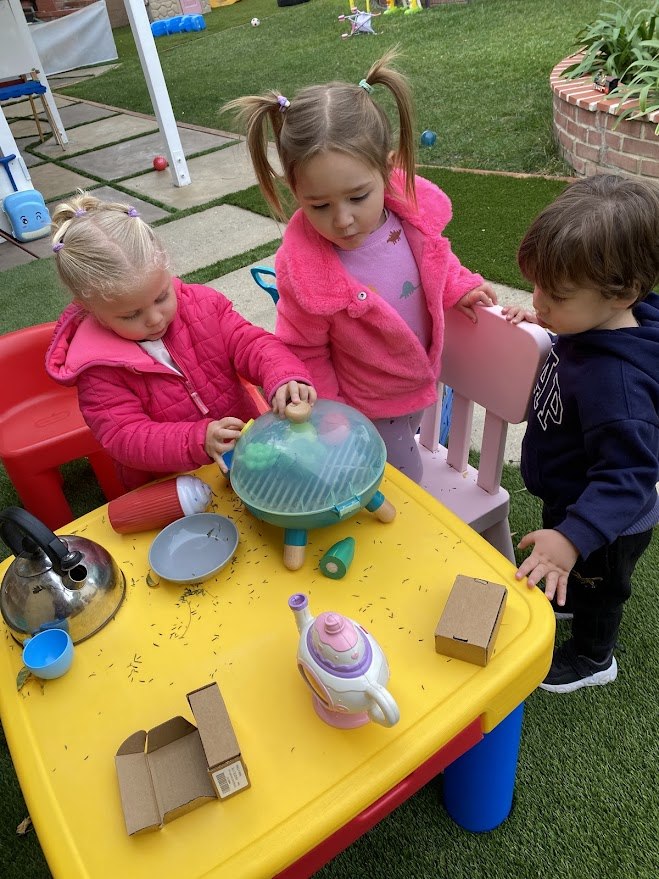 Children playing together at an outdoor table
